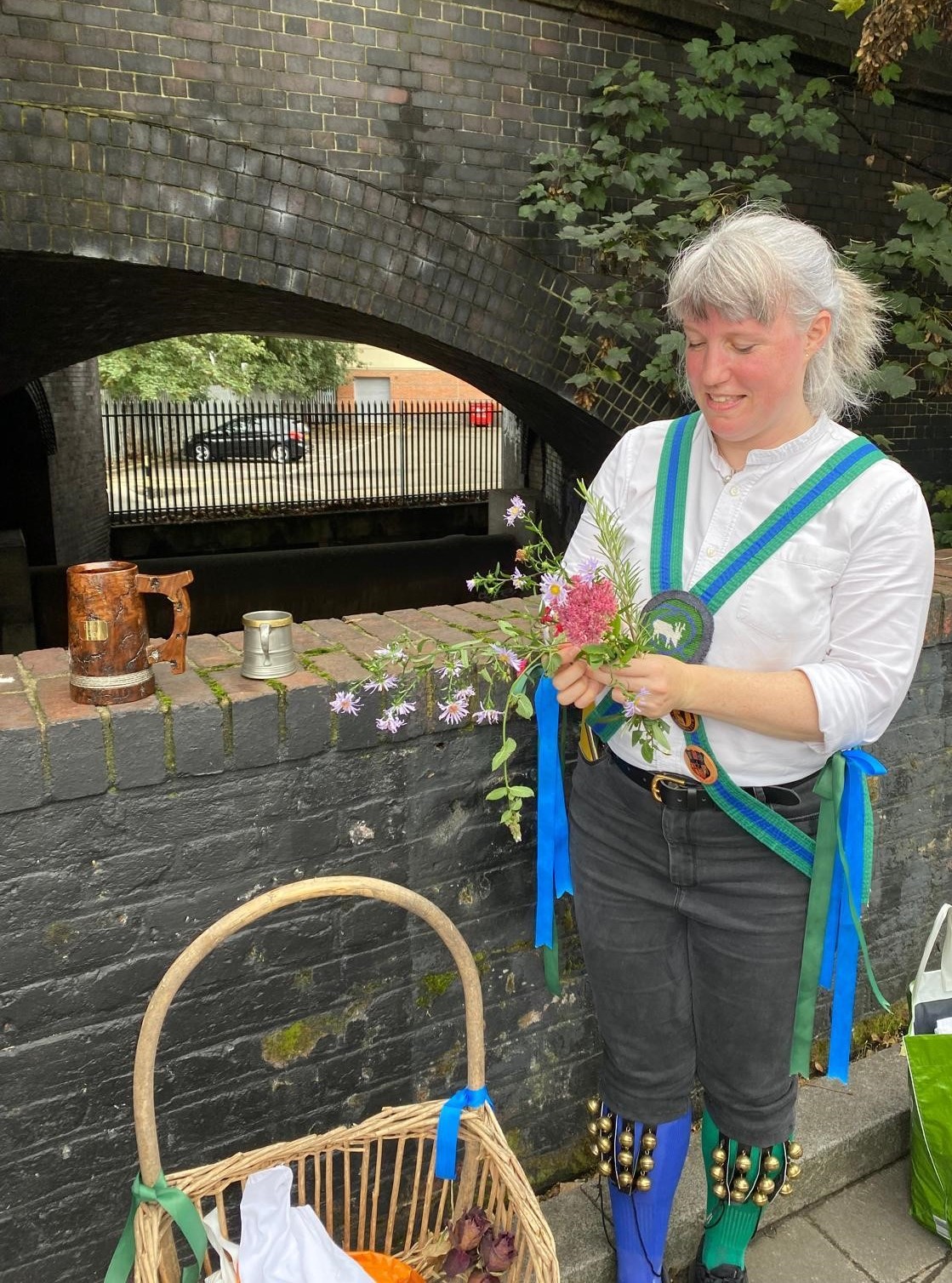 Quaggy Morris member gathering flowers to honour a stag mural